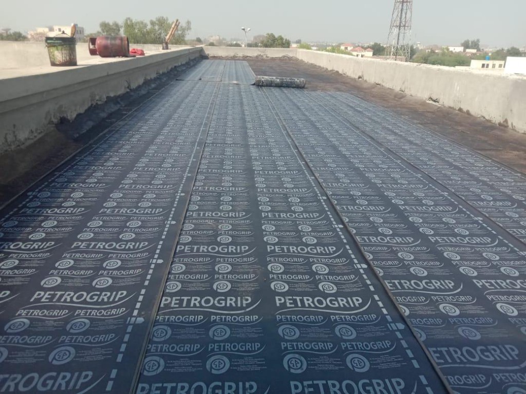 PetroGrip torch-applied membrane installation on a commercial rooftop in Pakistan